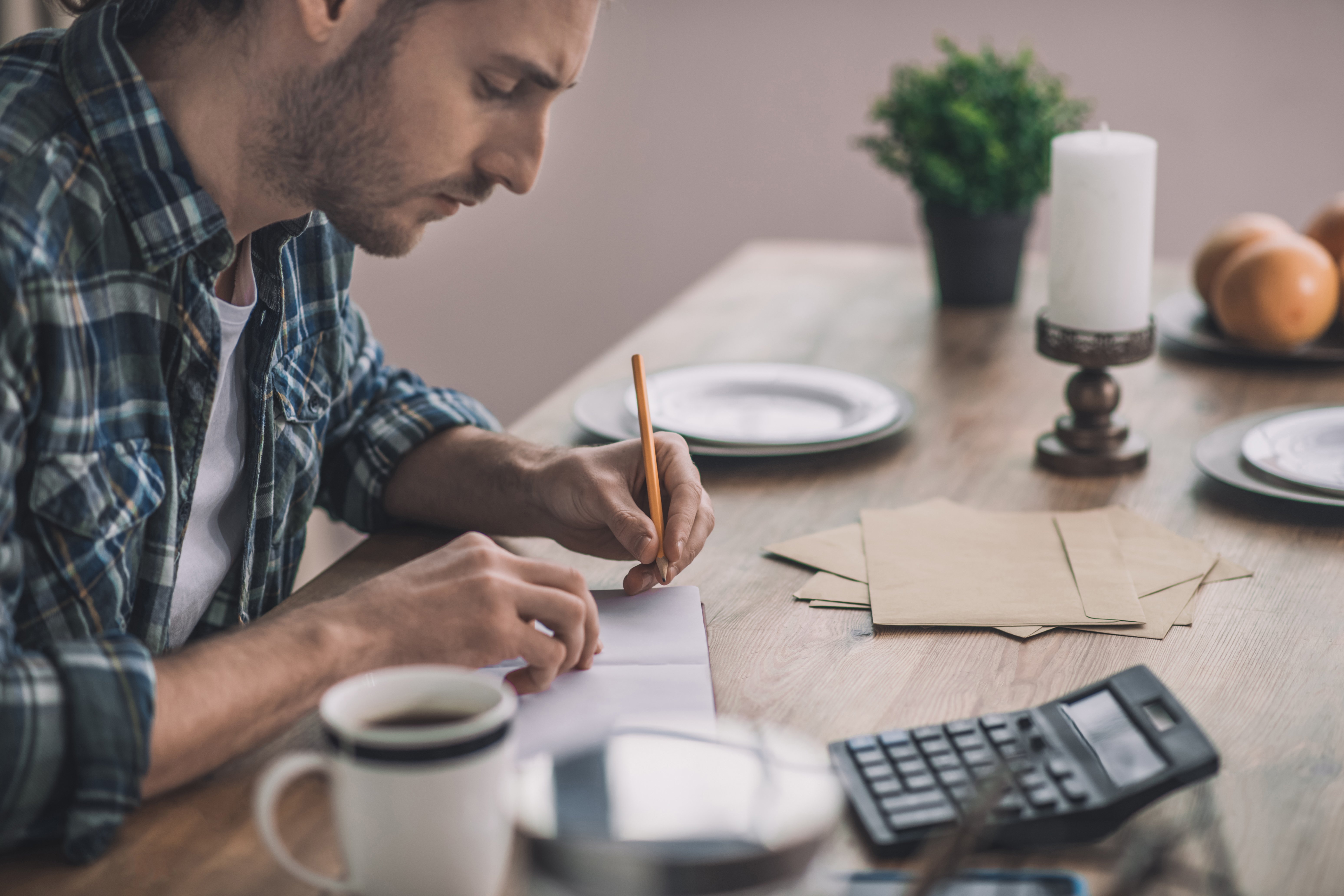 Hombre escribiendo y calculando los pros y los contras de su idea de negocio. Destaca la evaluación de aspectos positivos, como el control de datos, y negativos, como los costos y la complejidad técnica, en el contexto empresarial.